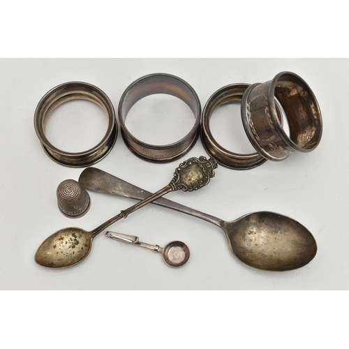 168 - AN ASSORTMENT OF SILVER ITEMS, to include four silver napkin rings, a tea spoon, a spoon a thimble a... 