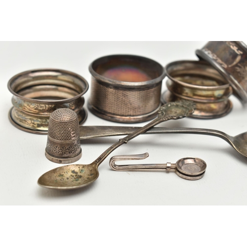 168 - AN ASSORTMENT OF SILVER ITEMS, to include four silver napkin rings, a tea spoon, a spoon a thimble a... 