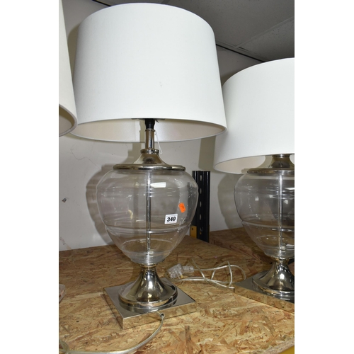 340 - TWO MODERN TABLE LAMPS, with glass bodies and cream shades, height to top of fitting approximately 5... 