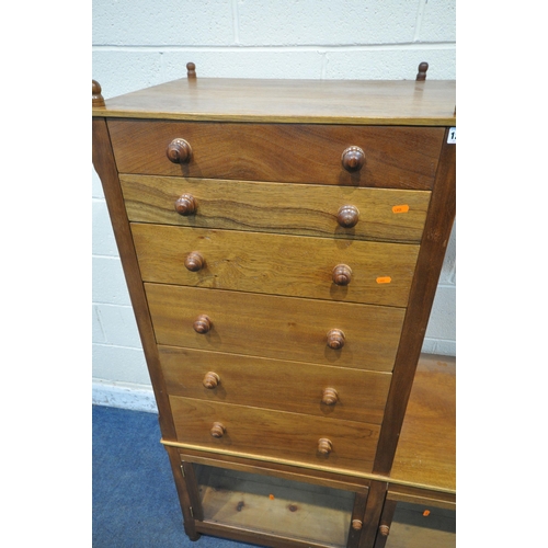 1227 - A MID CENTURY WALNUT CABINET, with six finials, six graduated drawers, atop a base with two glazed d... 