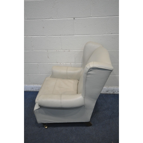 1229 - A CREAM LEATHER UPHOLSTERED WING BACK ARMCHAIR, width 82cm x depth 85cm x height 102cm (condition re... 