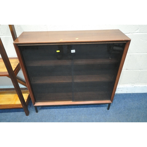 1244 - HERBERT GIBBS, A MID CENTURY TEAK BOOKCASE, with double smoked glass doors, that are enclosing two a... 