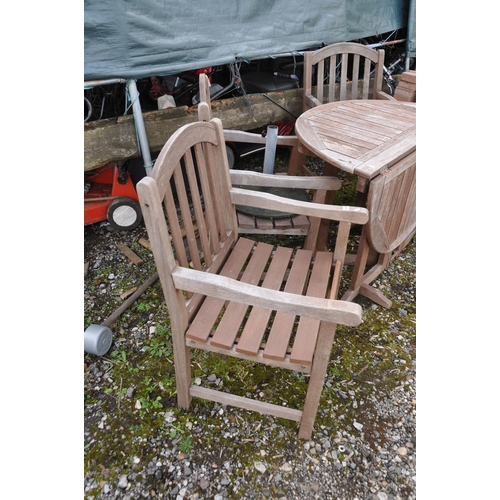 1005 - A CIRCULAR HARDWOOD GARDEN TABLE with four matching arm chairs, cushions  and a parasol base, table ... 