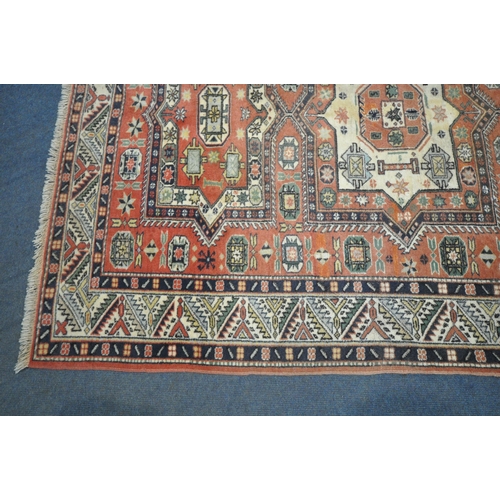 1286 - A RED GROUND PERSIAN RUG, with central medallions, repeating geometric patterns and multi-strap bord... 