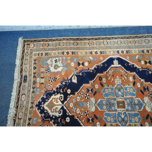 1287 - A RED GROUND PERSIAN RUG, with central medallion, repeating geometric and floral patterns, surrounde... 