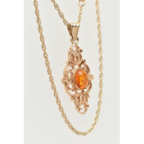 18 - A 9CT GOLD PENDANT AND CHAIN, of an openwork scrolling design with a central oval imitation amber ca... 