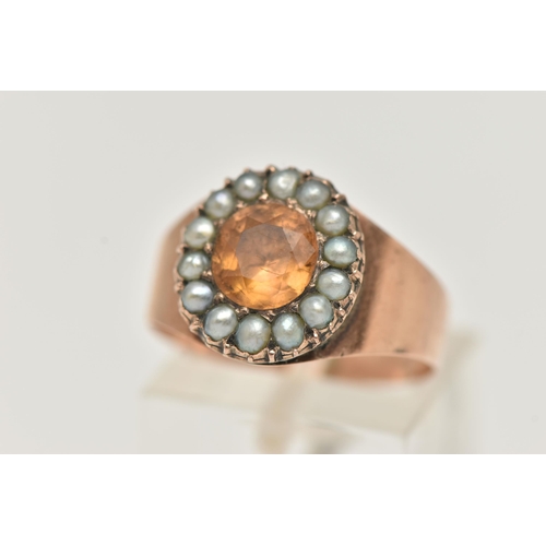 23 - A ROSE METAL CLUSTER RING, centering on an oval cut orange topaz within a surround of split pearls, ... 