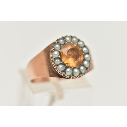 23 - A ROSE METAL CLUSTER RING, centering on an oval cut orange topaz within a surround of split pearls, ... 