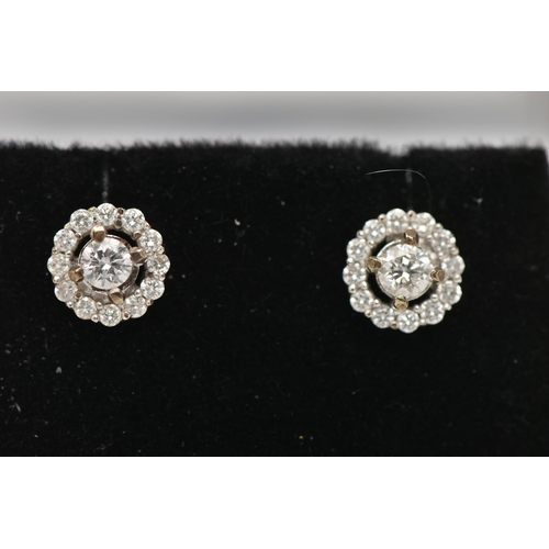 29 - A PAIR OF 9CT WHITE GOLD DIAMOND CLUSTER STUD EARRINGS, centering on a round brilliant cut diamond, ... 