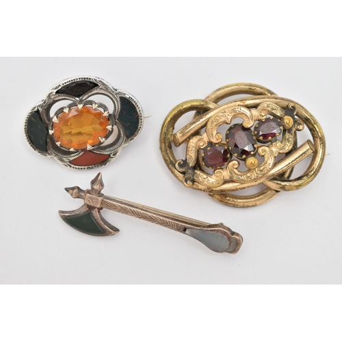 34 - THREE BROOCHES, to include a white metal Scottish hardstone set brooch, with an oval cut orange past... 