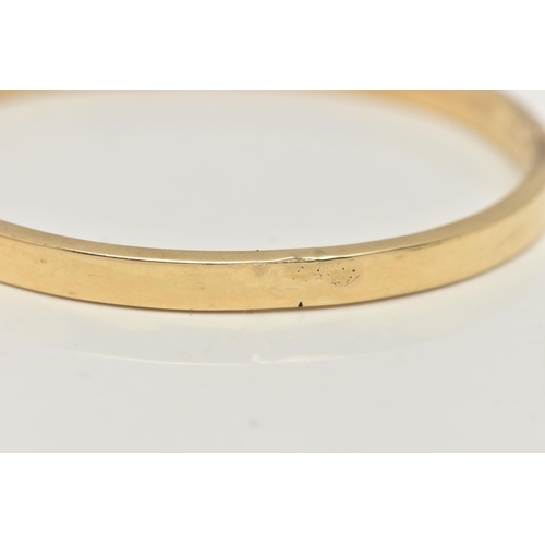 46 - A YELLOW METAL HINGED BANGLE, a hollow bangle fitted with an integrated push pin clasp, approximate ... 