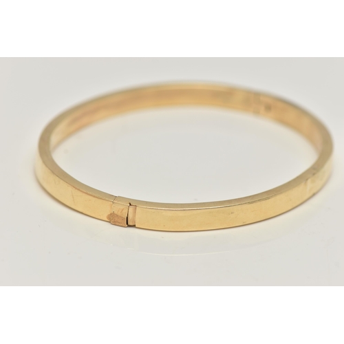 46 - A YELLOW METAL HINGED BANGLE, a hollow bangle fitted with an integrated push pin clasp, approximate ... 