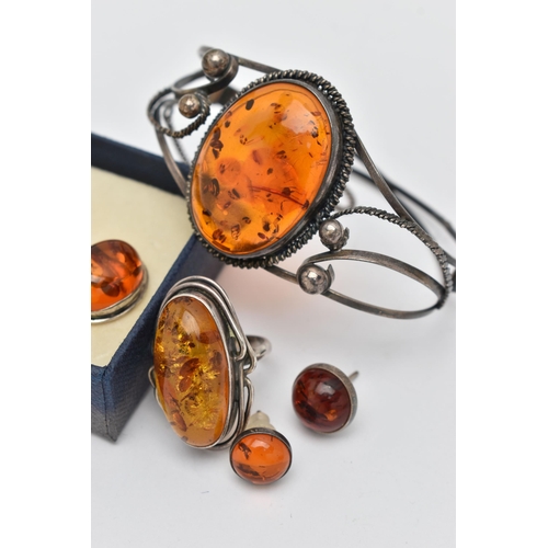 80 - A SMALL BAG OF JEWELLERY, to include a white metal bangle set with a large amber cabochon, unmarked,... 