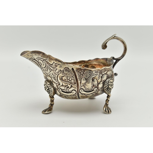 100 - AN IRISH SILVER GRAVY BOAT, early 20th century, embossed animal and floral pattern, with three lion ... 