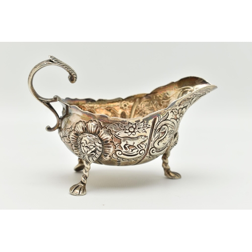 100 - AN IRISH SILVER GRAVY BOAT, early 20th century, embossed animal and floral pattern, with three lion ... 