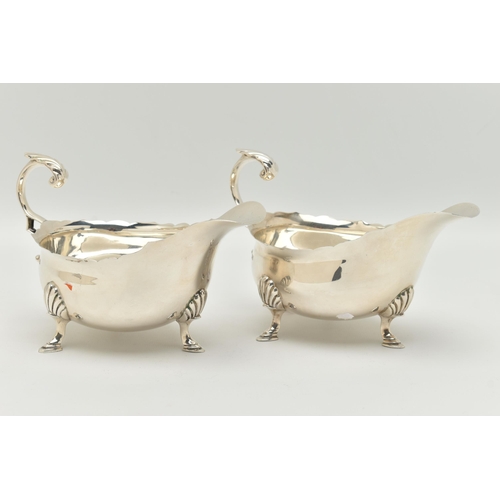 104 - A PAIR OF GEORGE V SAUCE BOATS, typical form silver sauce boats, scalloped rim, scrolled handle with... 