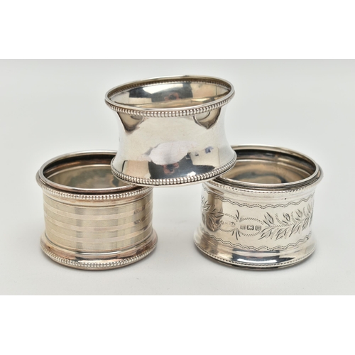 90 - THREE SILVER NAPKIN RINGS, all of different design, all with beaded edge detail, hallmarks for Birmi... 