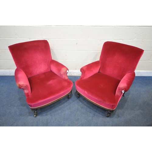 1354 - A PAIR OF EARLY 20TH CENTURY ARMCHAIRS, with maroon upholstery, on turned front legs and brass casto... 