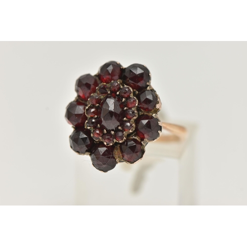 15 - A GARNET CLUSTER RING, the early 20th century cluster set with faceted garnets, to the later mid 20t... 
