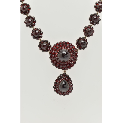 21 - A LATE 19TH CENTURY GARNET NECKLACE, the silver gilt necklace designed as a central circular garnet ... 