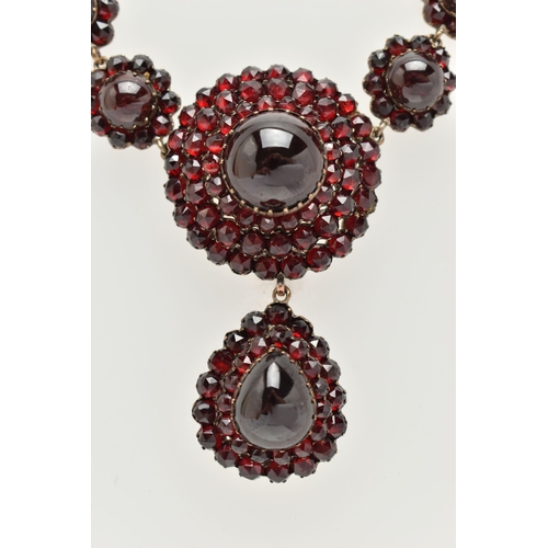 21 - A LATE 19TH CENTURY GARNET NECKLACE, the silver gilt necklace designed as a central circular garnet ... 