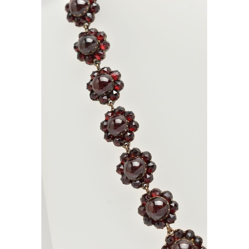 21 - A LATE 19TH CENTURY GARNET NECKLACE, the silver gilt necklace designed as a central circular garnet ... 