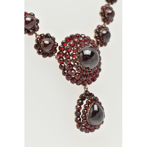 21 - A LATE 19TH CENTURY GARNET NECKLACE, the silver gilt necklace designed as a central circular garnet ... 