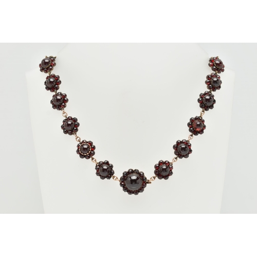 21 - A LATE 19TH CENTURY GARNET NECKLACE, the silver gilt necklace designed as a central circular garnet ... 