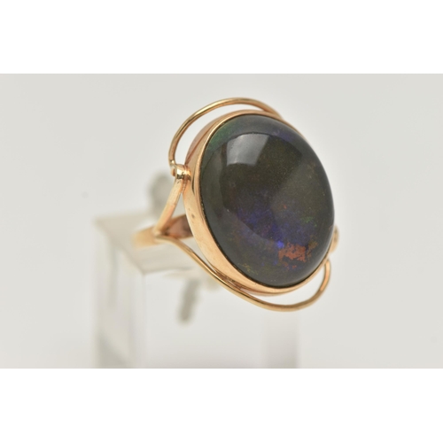 6 - A TREATED OPAL RING, the oval opal cabochon in a collet setting to the bifurcated shoulders and oute... 