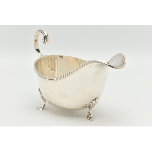 121 - A SILVER GRAVY BOAT, polished form, raised on three hoof feet with shell pattern, and a scroll handl... 