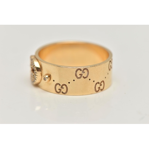 77 - AN 18CT GOLD 'GUCCI' ICON BAND RING, a wide yellow metal band with a repetitive 'Gucci' logo and a p... 