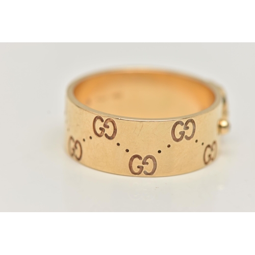 77 - AN 18CT GOLD 'GUCCI' ICON BAND RING, a wide yellow metal band with a repetitive 'Gucci' logo and a p... 