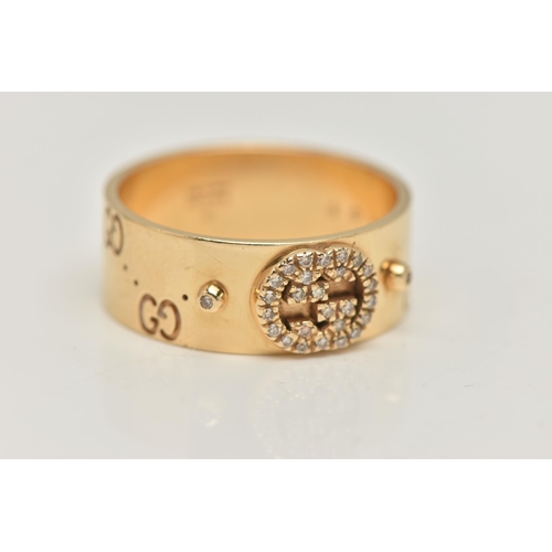 77 - AN 18CT GOLD 'GUCCI' ICON BAND RING, a wide yellow metal band with a repetitive 'Gucci' logo and a p... 