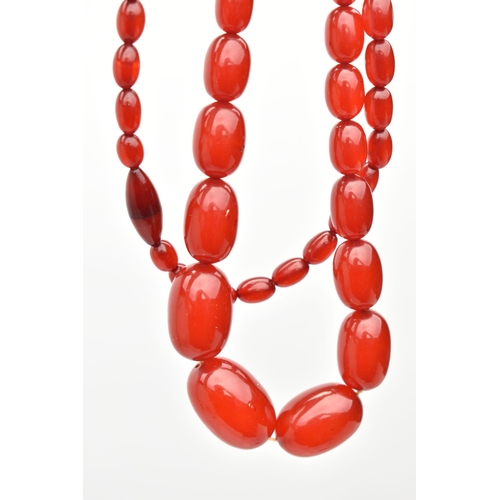 86 - A BAKELITE CHERRY AMBER BEAD NECKLACE, a single strand of oval beads, largest bead measures approxim... 