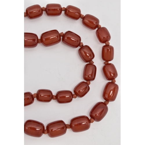 88 - A BAKELITE CHERRY AMBER BEAD NECKLACE, a single strand of rectangular oval beads, largest bead measu... 