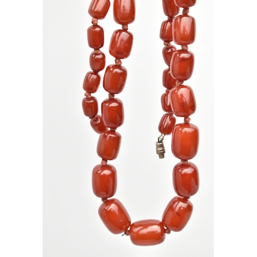 88 - A BAKELITE CHERRY AMBER BEAD NECKLACE, a single strand of rectangular oval beads, largest bead measu... 