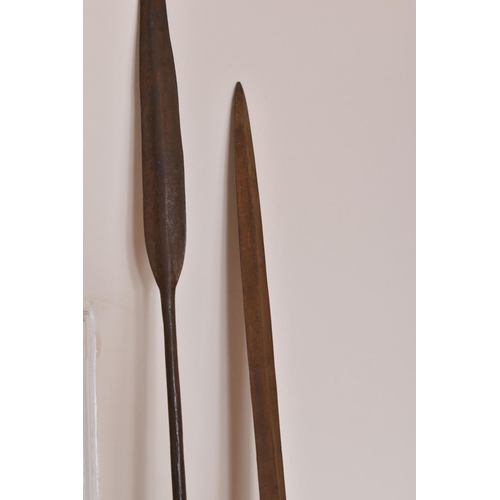 549 - THREE TRIBAL HUNTING SPEARS, the first features a wooden shaft and a grooved arrow shaped steel tip,... 