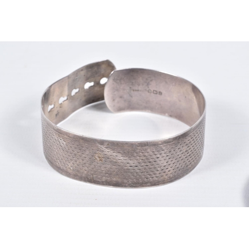 13 - FOUR ITEMS OF JEWELLERY, to include a silver wide engine turned pattern belt designed bangle, hallma... 