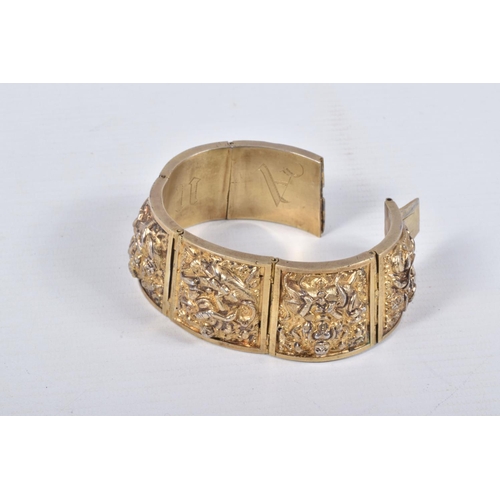 18 - A VICTORIAN GILT BRACELET, comprised of six slightly tapered panels, embossed with an Indian design,... 