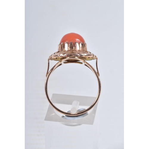 23 - A YELLOW METAL CORAL RING, set with a raised coral cabochon with pin to the centre, in a claw settin... 