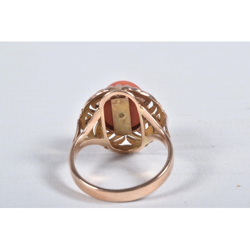 23 - A YELLOW METAL CORAL RING, set with a raised coral cabochon with pin to the centre, in a claw settin... 