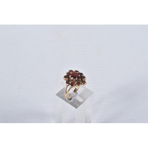 46 - A 9CT GOLD GARNET CLUSTER RING, designed as a central pear shape garnet within a circular cut garnet... 