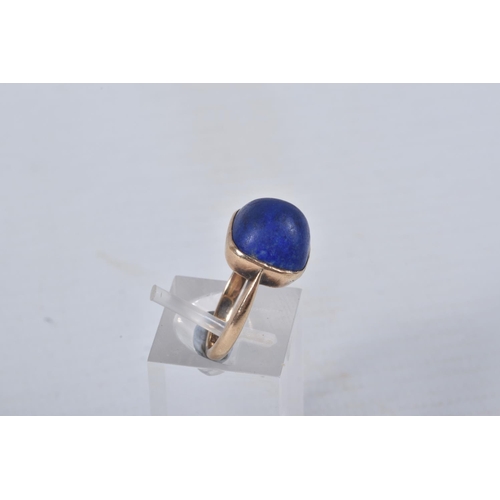 49 - A LAPIS LAZULI RING, designed as a square lapis lazuli cabochon in a collet setting to the plain ban... 