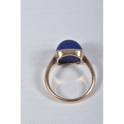 49 - A LAPIS LAZULI RING, designed as a square lapis lazuli cabochon in a collet setting to the plain ban... 