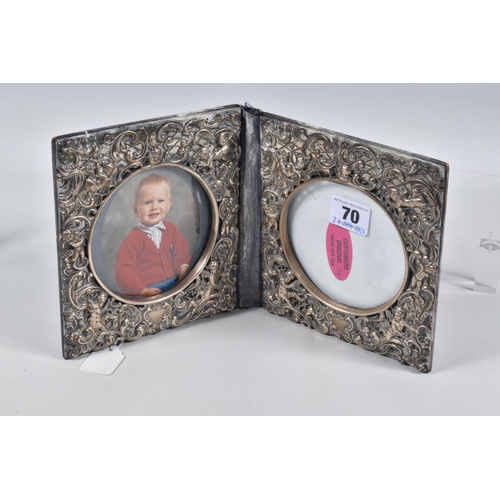 70 - A DOUBLE PHOTO FRAME, white metal lined frame, with embossed foliate pattern with cherubs, folding f... 