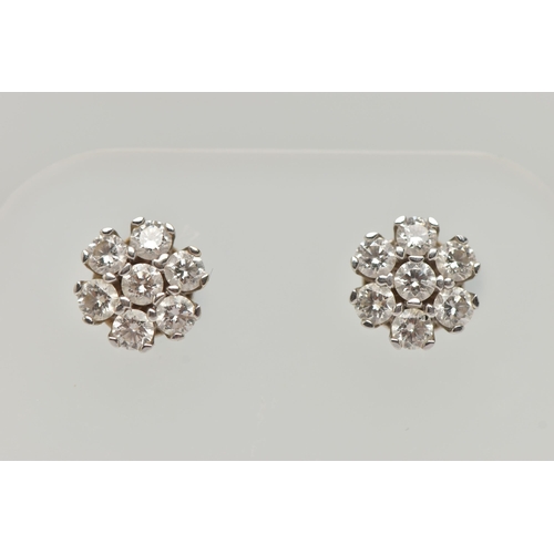 3 - A PAIR OF WHITE METAL DIAMOND CLUSTER EARRINGS, each of a flower shape, set with seven round brillia... 