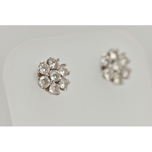 3 - A PAIR OF WHITE METAL DIAMOND CLUSTER EARRINGS, each of a flower shape, set with seven round brillia... 