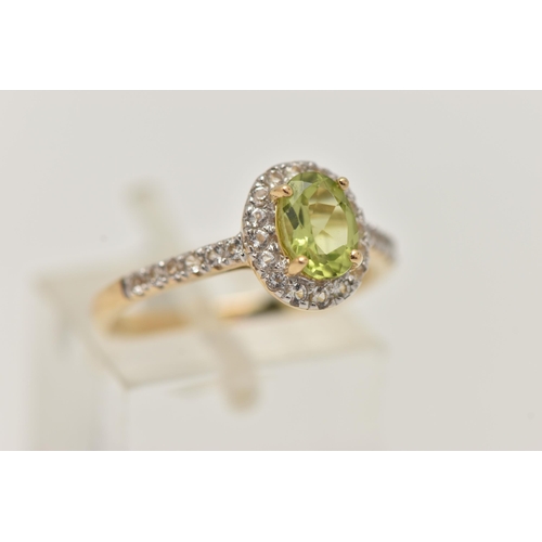 42 - A 9CT GOLD PERIDOT DRESS RING, a principally set oval cut peridot, prong set in yellow gold, set wit... 