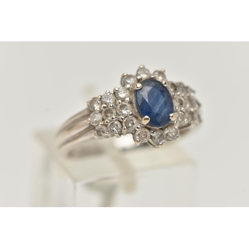 6 - AN 18CT WHITE GOLD SAPPHIRE AND DIAMOND CLUSTER RING, centrally set with an oval cut blue sapphire, ... 