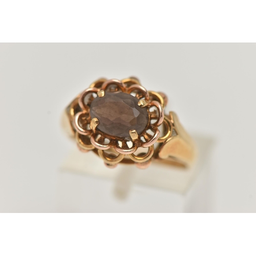 76 - A YELLOW METAL SMOKY QUARTZ RING, set with an oval cut smoky quartz, in a four claw open work settin... 